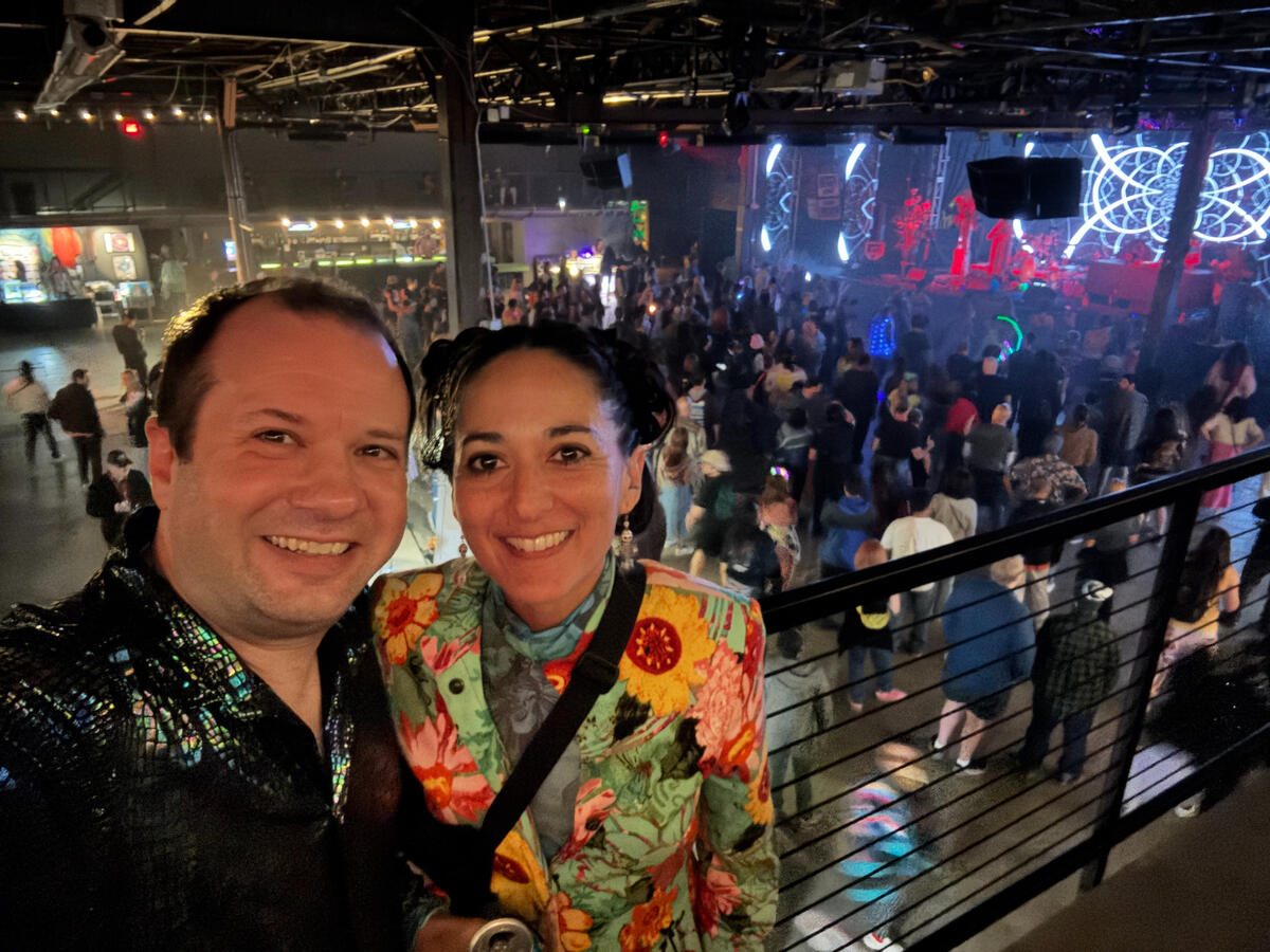 Untitled Michael and Michelle selfie inside a dance club, taken from the second floor with a view of the main floor beneath/behind them.